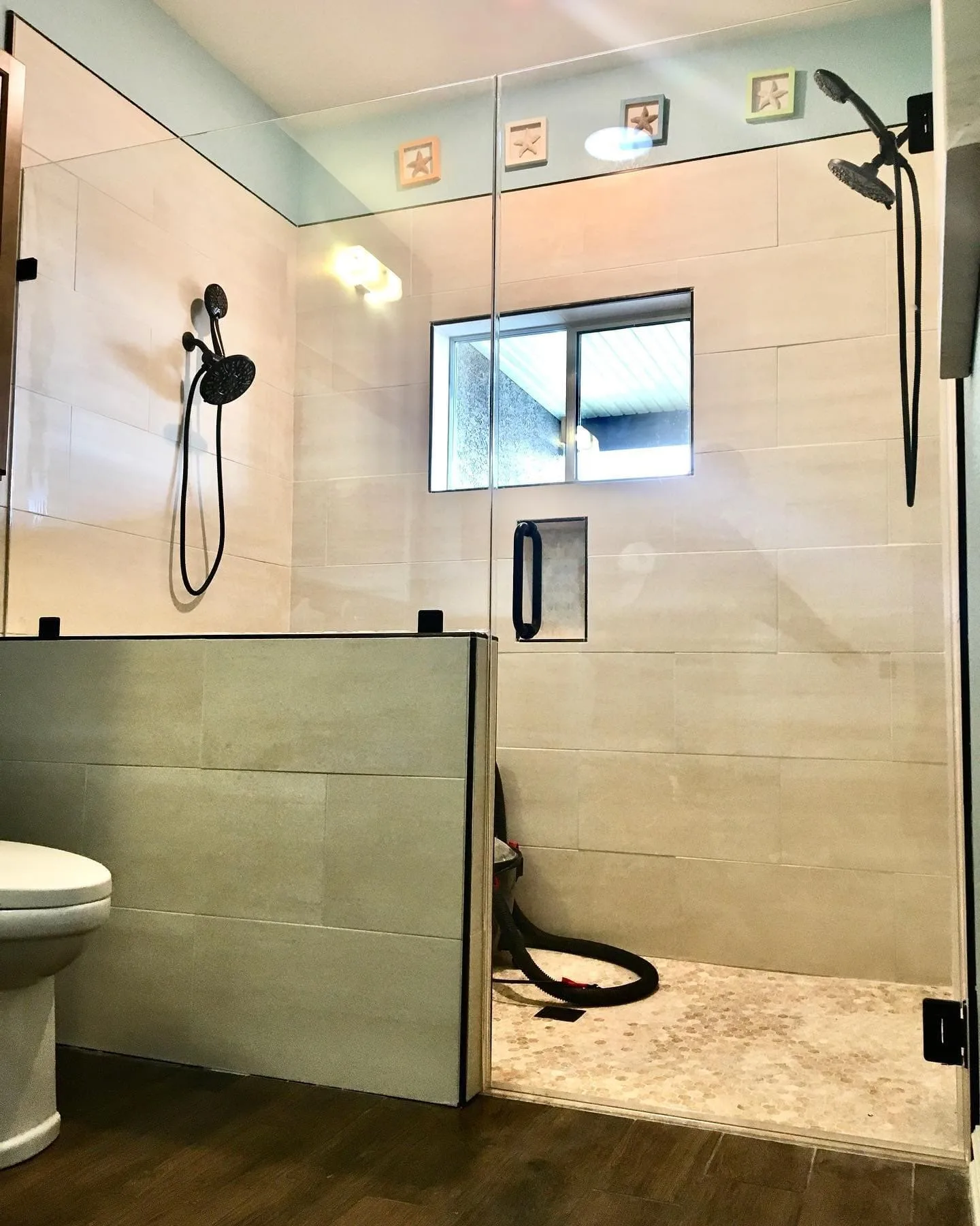 Large shower with partial glass panel and black fixtures