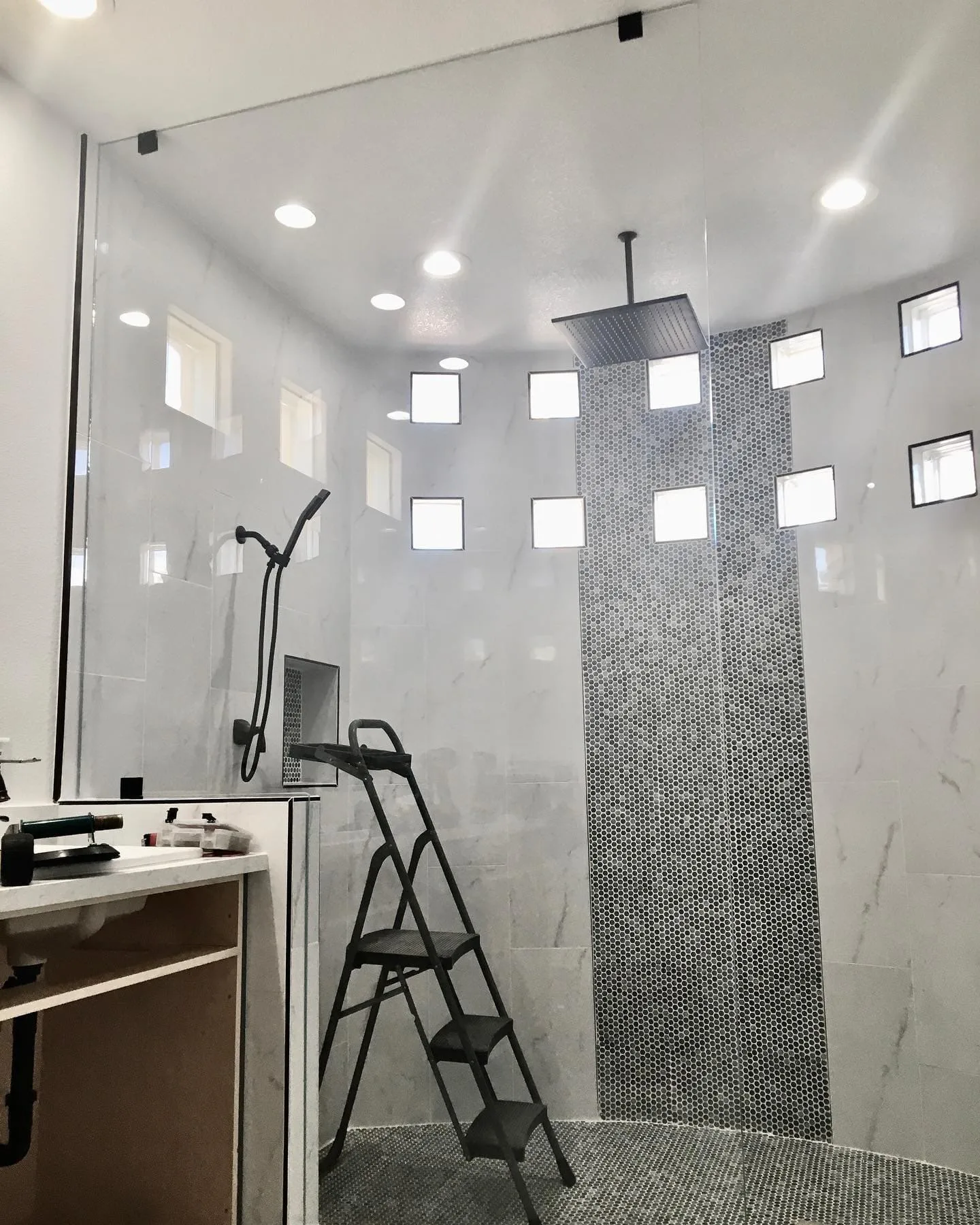 Modern walk-in shower with penny tile accent and multiple shower heads