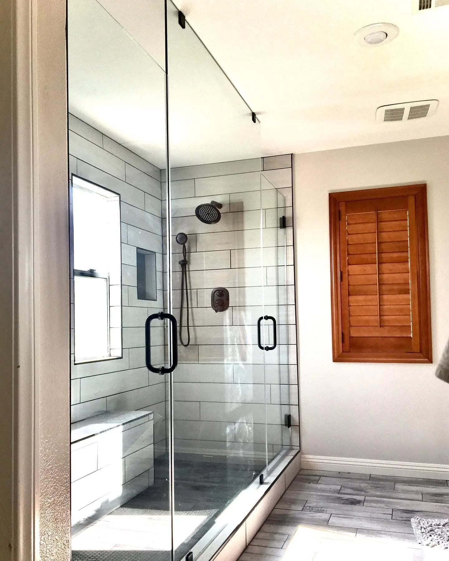 Walk-in shower with black hardware and subway tile