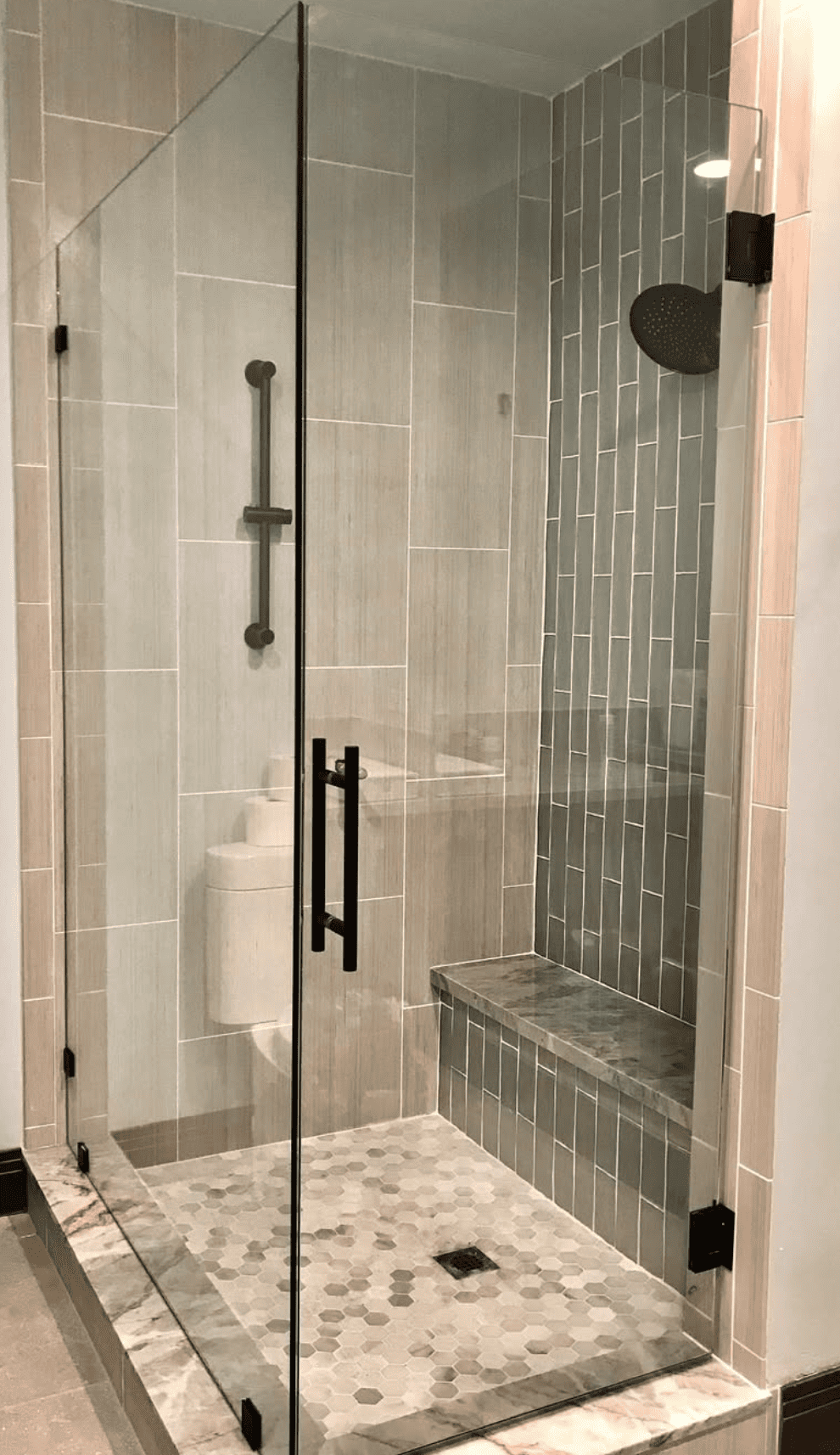 Modern hinged glass shower door with black fixtures and geometric tile design - professional installation Las Vegas